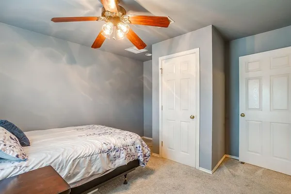 a bedroom with a bed and a chandelier fan