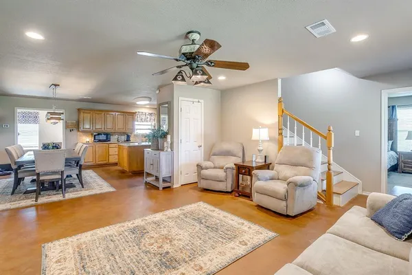 a living room with furniture and a dining table with wooden floor