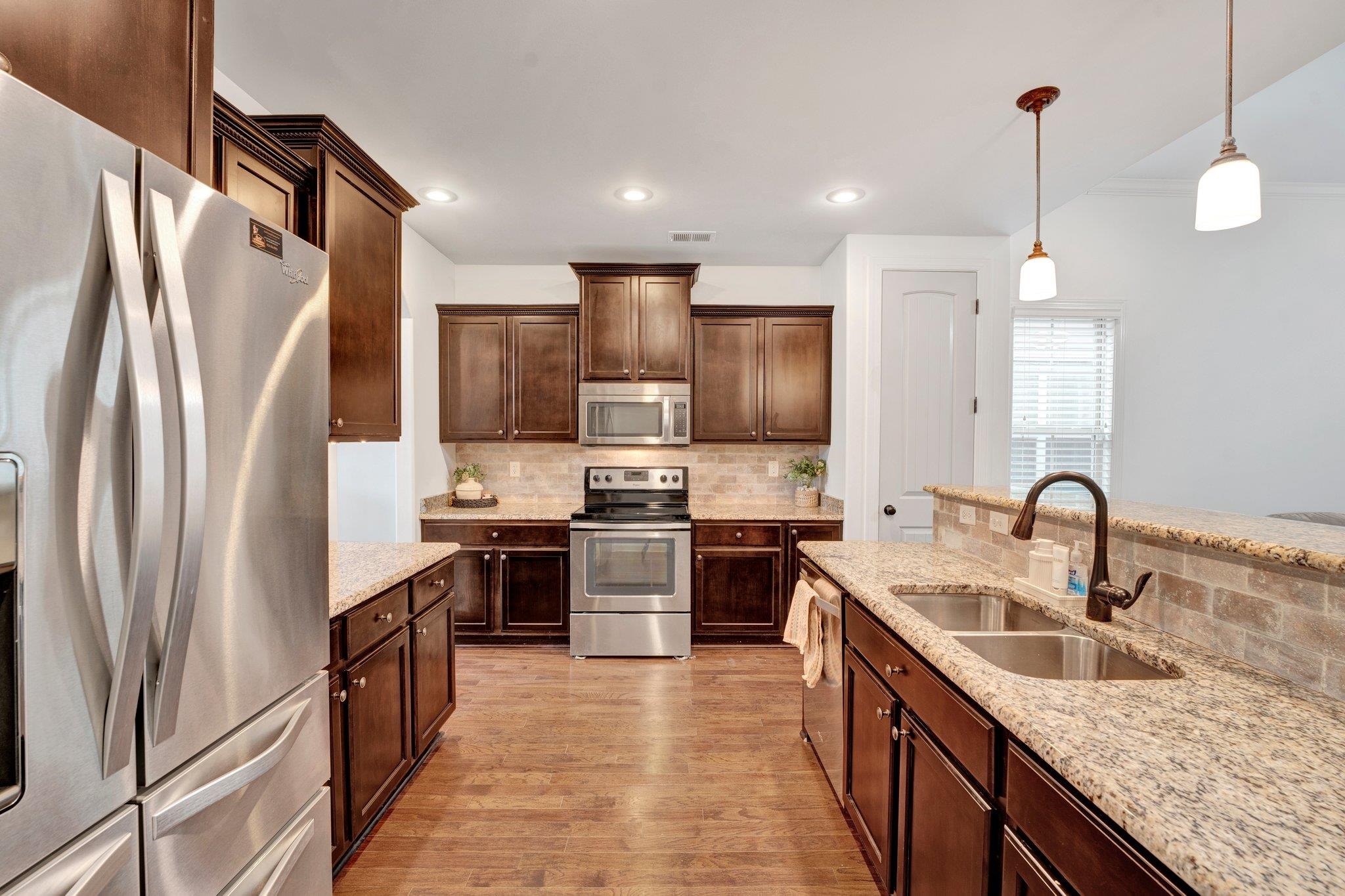 1965 Rochelle Lane Cordova, TN 38016 - Photo 9 of 40 a kitchen with stainless steel appliances granite countertop a sink refrigerator and cabinets