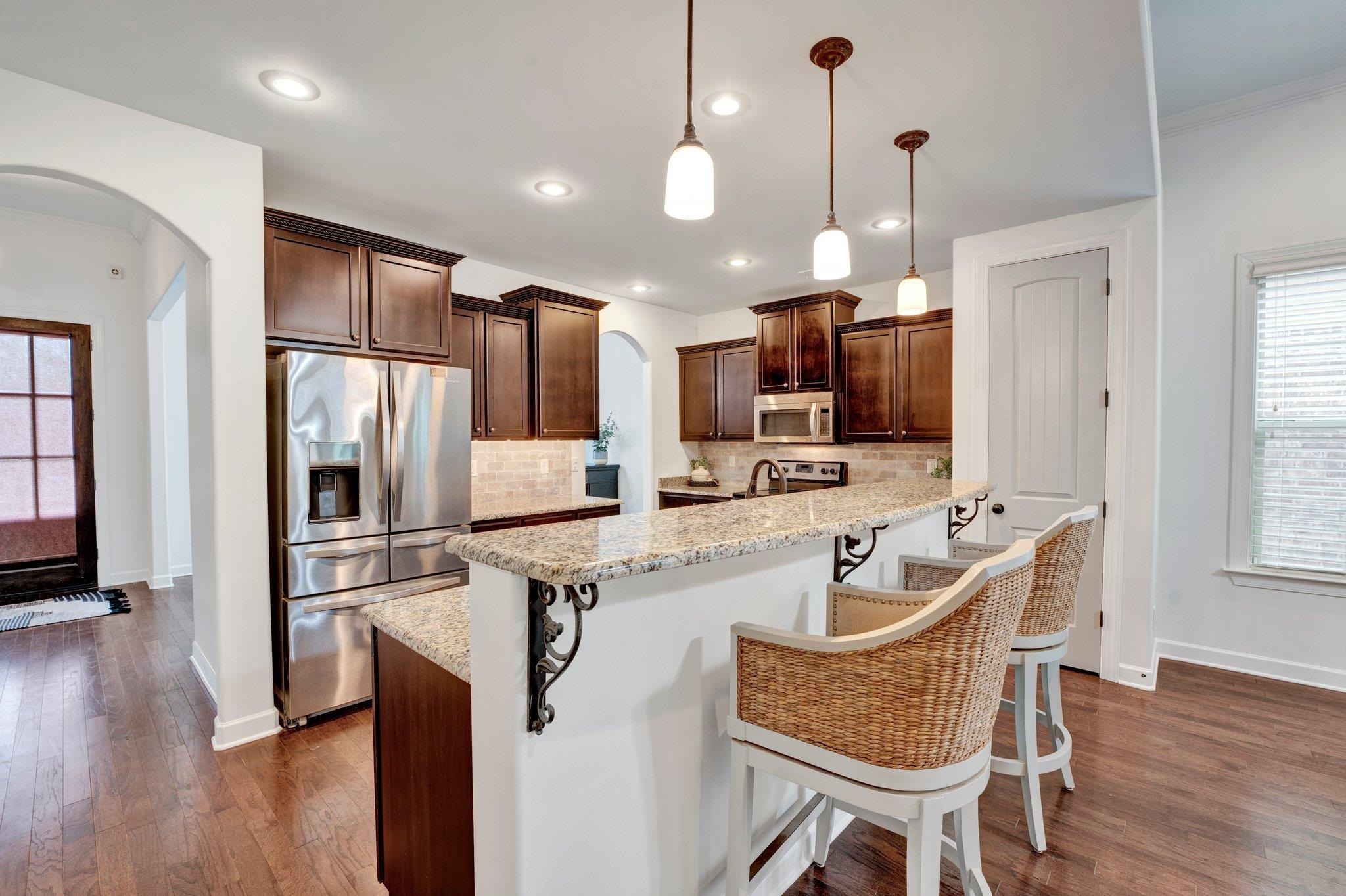 1965 Rochelle Lane Cordova, TN 38016 - Photo 10 of 40 a kitchen with stainless steel appliances granite countertop a refrigerator a oven a sink dishwasher a dining table and chairs with wooden floor