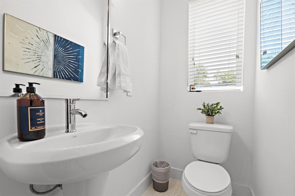 1586 West Tidwell Road Houston, TX 77091 - Photo 5 of 14 a bathroom with a toilet a sink and mirror