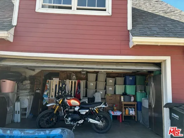 a view of a garage with two chair and a barbeque
