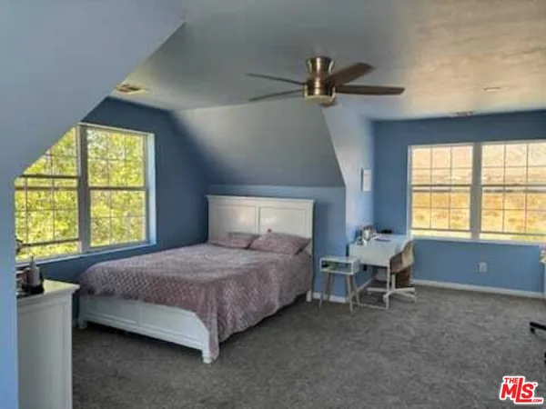 a spacious bedroom with a bed and a window