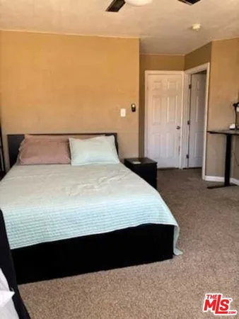 a large bed sitting in a room next to a cabinet