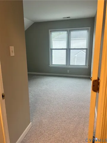 a view of a white house with large windows and a small yard