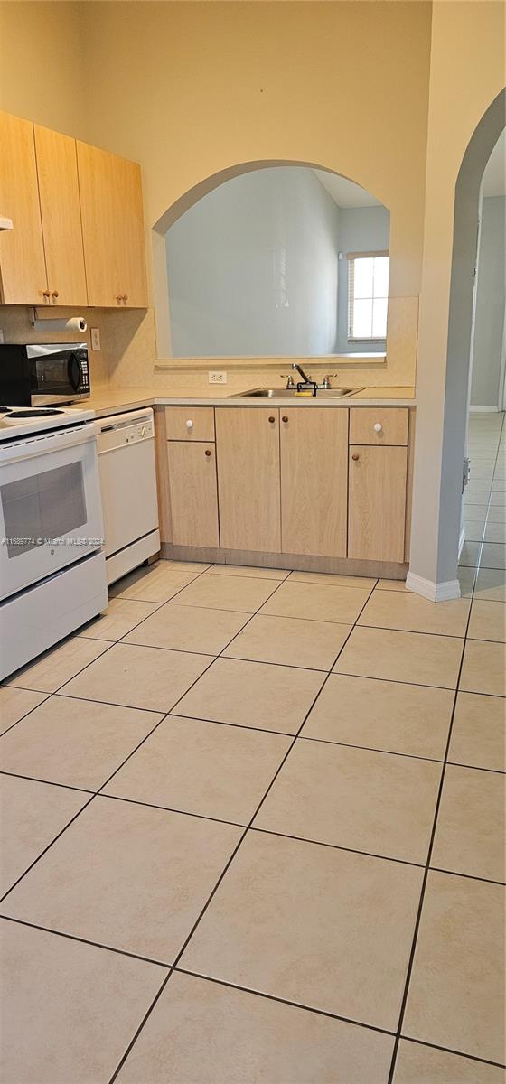 2910 Southeast 12th Road, Unit 20429 Homestead, FL 33035 - Photo 5 of 16 a kitchen with granite countertop white cabinets and white appliances