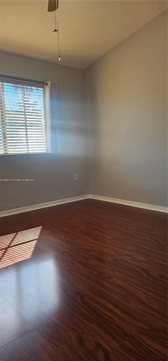 2910 Southeast 12th Road, Unit 20429 Homestead, FL 33035 - Photo 10 of 16 an empty room with wooden floor and windows