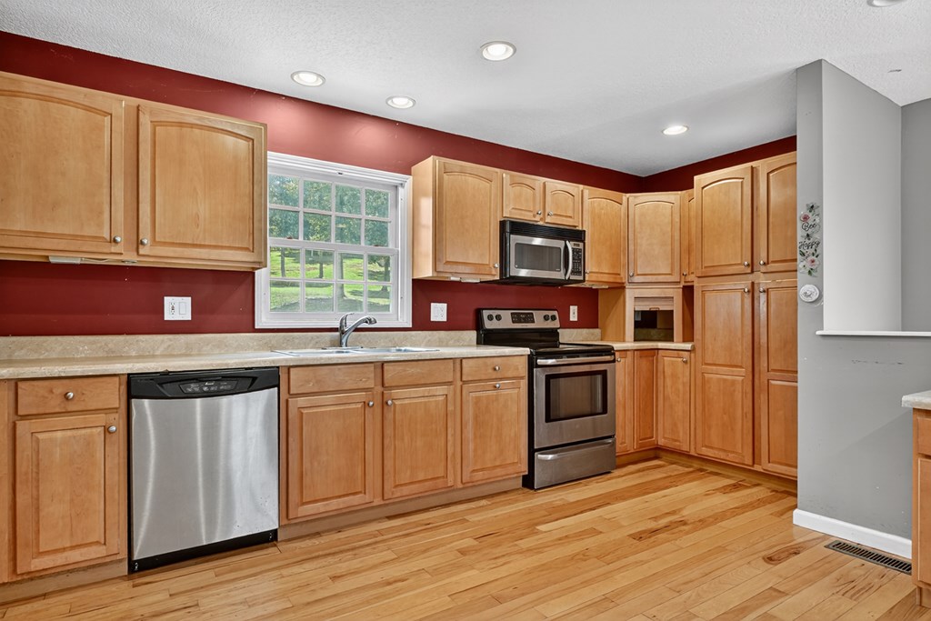 280 Star Creek Crossing Morganton, GA 30560 - Photo 72 of 100 a kitchen with stainless steel appliances granite countertop a refrigerator a sink dishwasher a stove and white cabinets with wooden floor
