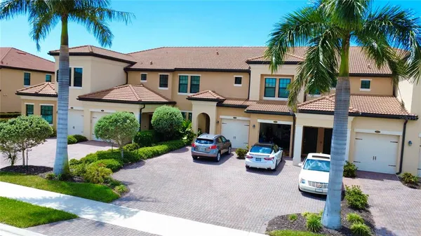 a front view of a house with garage and plants