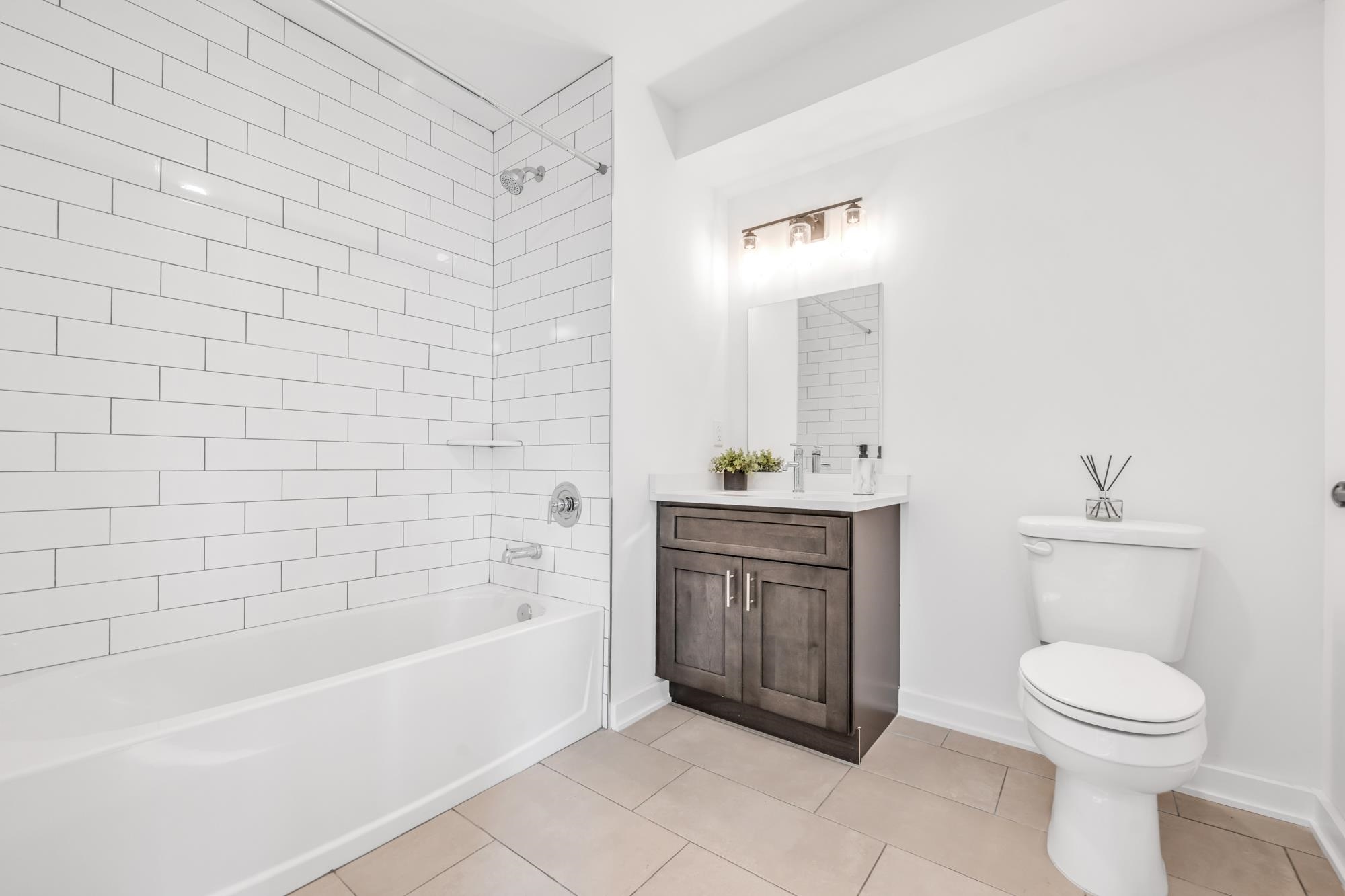 315 Railroad Avenue, Unit 108 East Rutherford, NJ 07073 - Photo 13 of 28 a bathroom with a bathtub sink vanity mirror and toilet