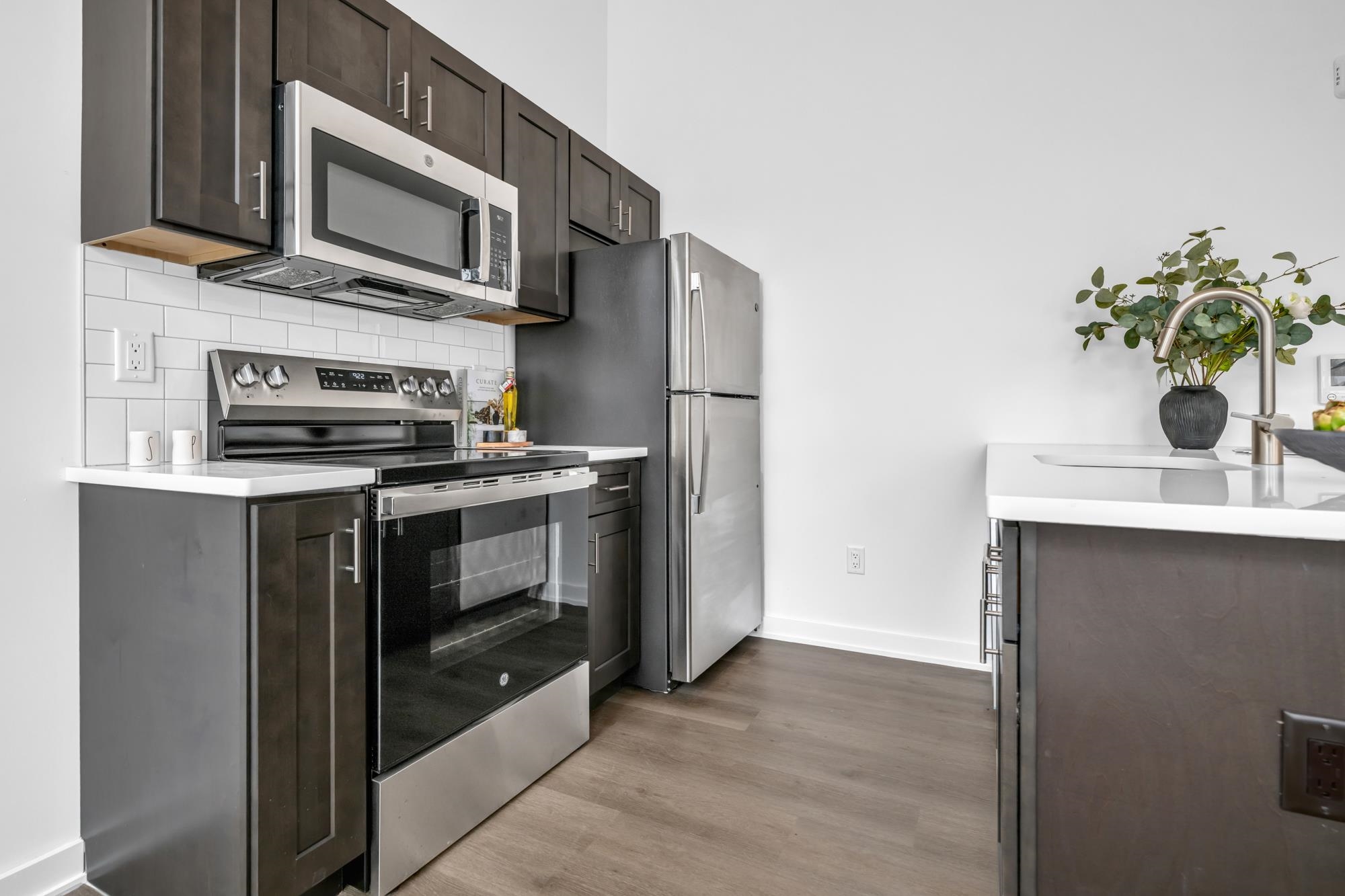 315 Railroad Avenue, Unit 108 East Rutherford, NJ 07073 - Photo 8 of 28 a kitchen with stainless steel appliances a stove a microwave and a sink