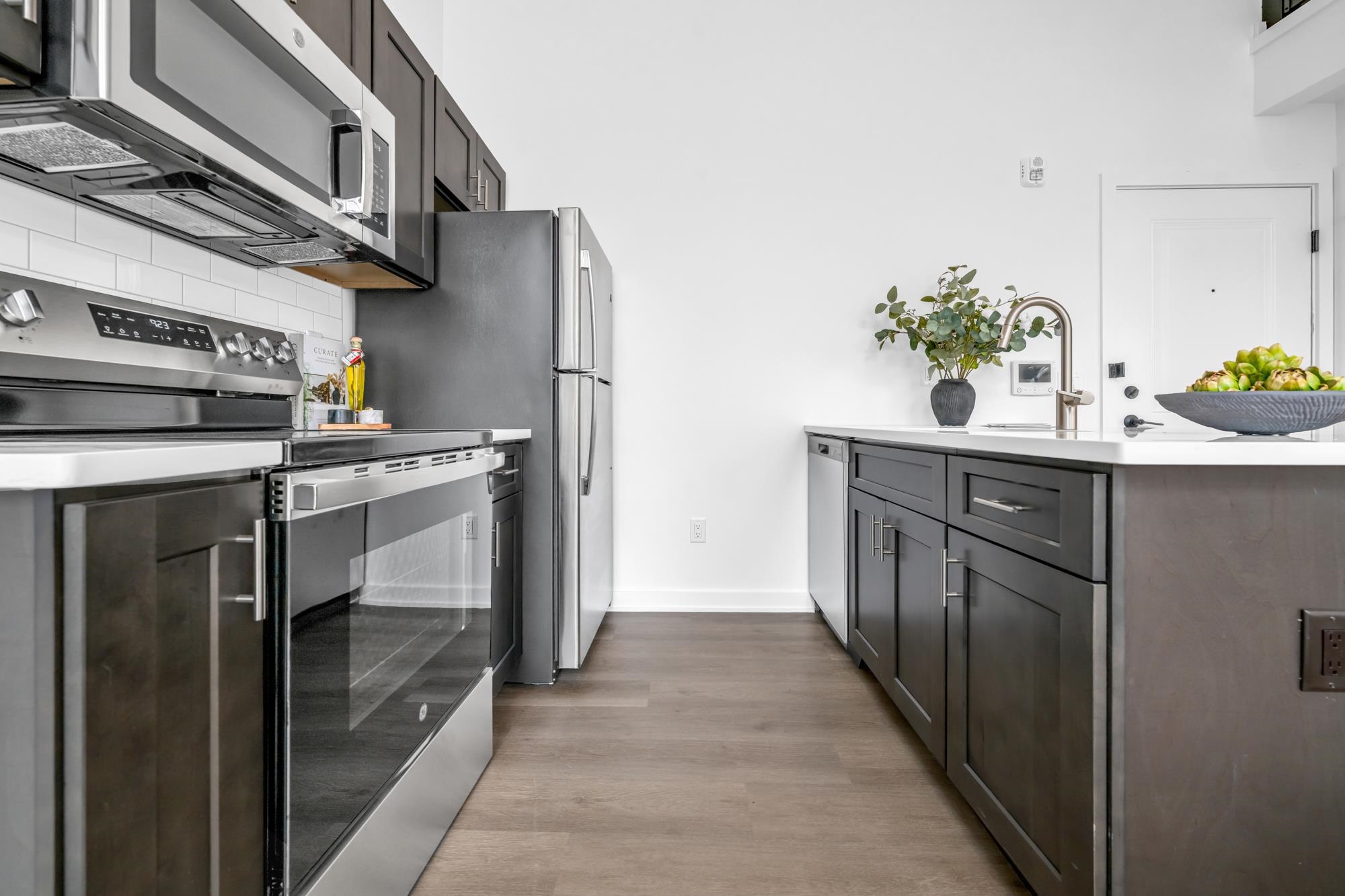 315 Railroad Avenue, Unit 108 East Rutherford, NJ 07073 - Photo 9 of 28 a kitchen with stainless steel appliances a sink and a refrigerator
