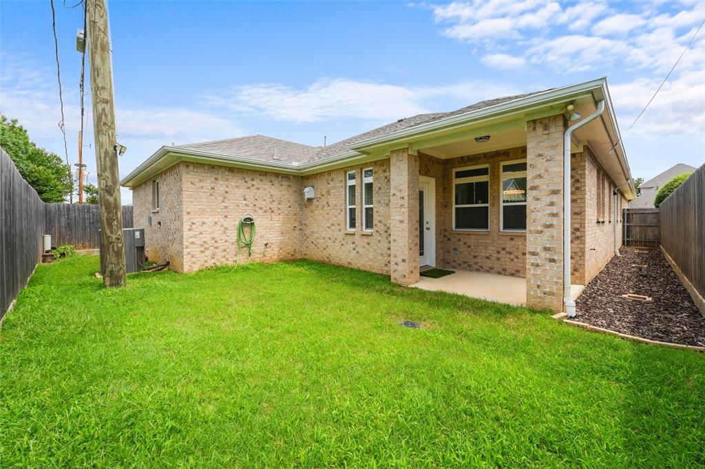 3807 Winding Road Arlington, TX 76016 - Photo 21 of 23 Expansive backyard featuring a manicured lawn, full privacy fencing, and a covered concrete patio