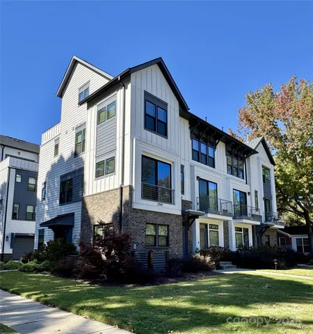 a front view of a house with a garden and trees