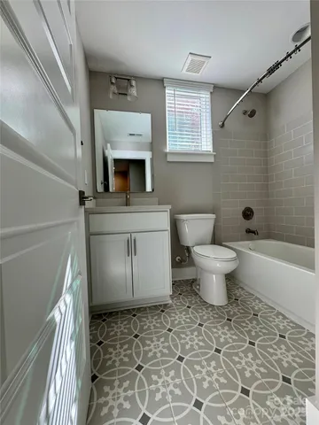 a bathroom with a sink toilet a mirror and bathtub