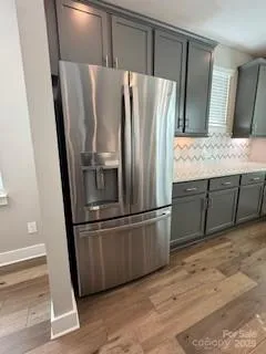 a metallic refrigerator freezer sitting inside of a kitchen