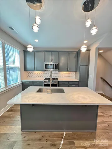 a large white kitchen with kitchen island a stove a sink a refrigerator and a stove