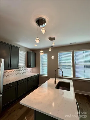 a large kitchen with a table chairs and a refrigerator
