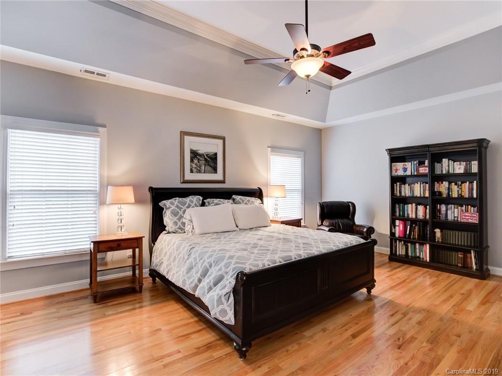 1502 Hubbard Court Fort Mill, SC 29708 - Photo 21 of 36 a spacious bedroom with a bed and a chandelier