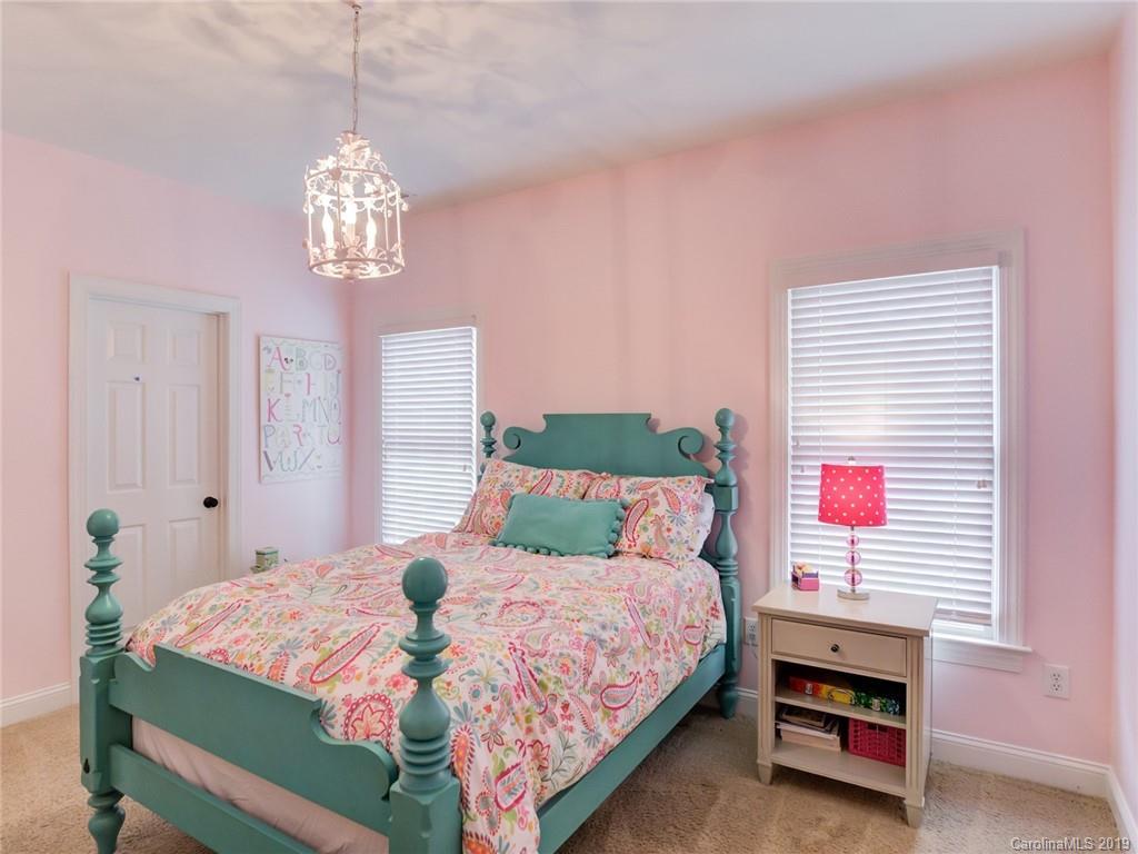 1502 Hubbard Court Fort Mill, SC 29708 - Photo 27 of 36 a bedroom with a bed and a chandelier