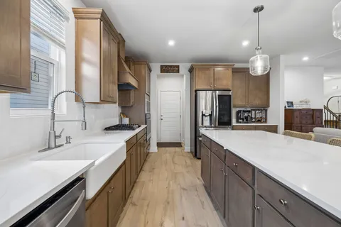 a room with furniture a flat screen tv and kitchen view