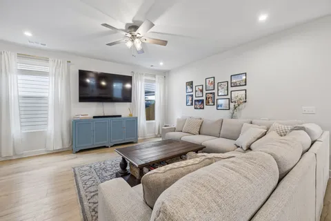 a living room with furniture ceiling fan and a rug