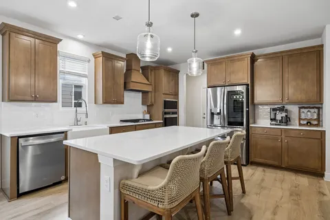 a large kitchen with kitchen island a sink stainless steel appliances and cabinets