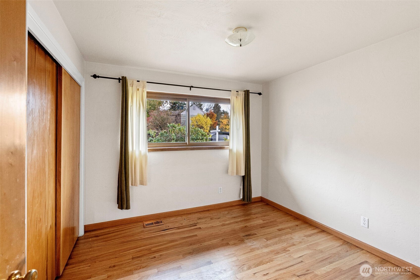 2821 Sanders Avenue Bremerton, WA 98310 - Photo 19 of 40 a view of an empty room with wooden floor and a window
