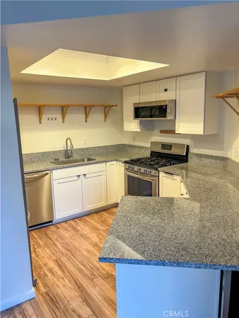 a kitchen with metallic refrigerator and sink