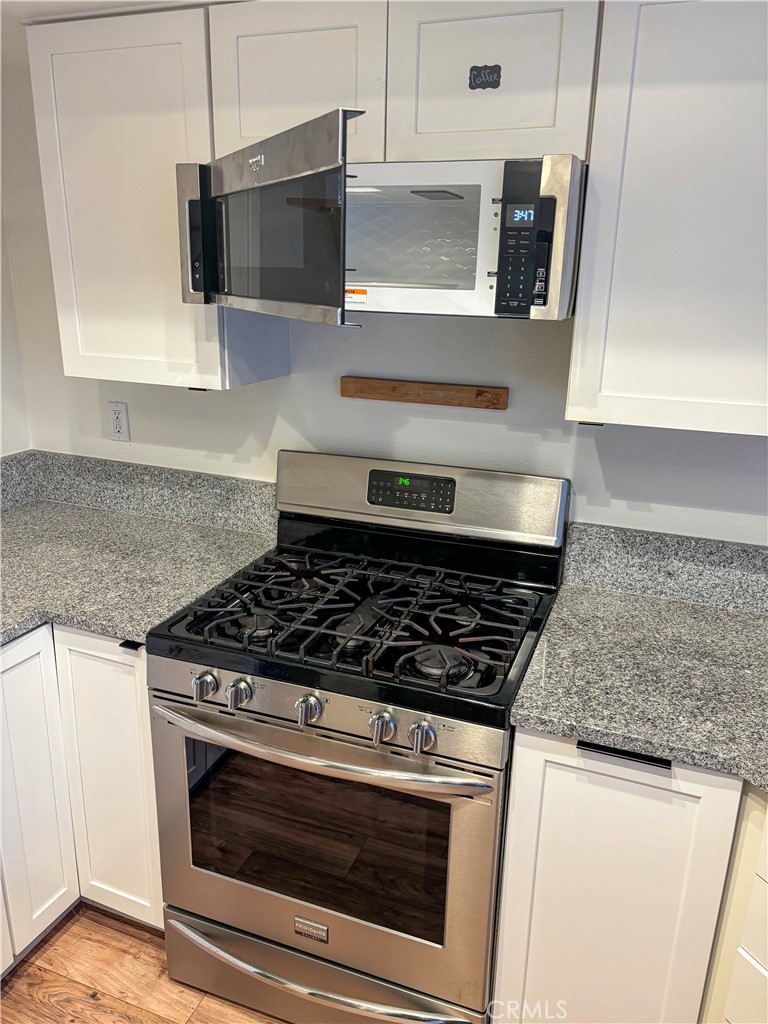 1445 Prefumo Canyon Road, Unit 20 San Luis Obispo, CA 93405 - Photo 6 of 19 a kitchen with stainless steel appliances granite countertop a stove and a microwave