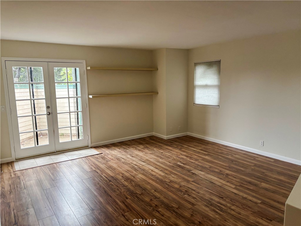 1445 Prefumo Canyon Road, Unit 20 San Luis Obispo, CA 93405 - Photo 9 of 19 an empty room with wooden floor and windows