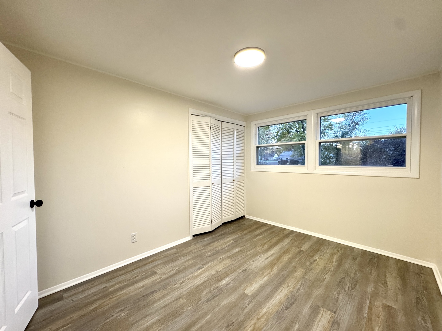 1630 Jonathan Avenue Rockford, IL 61103 - Photo 3 of 23 an empty room with wooden floor and windows