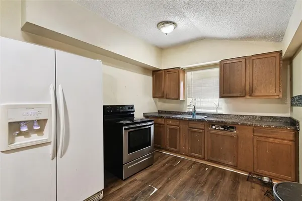 a kitchen with granite countertop stainless steel appliances and wooden cabinets