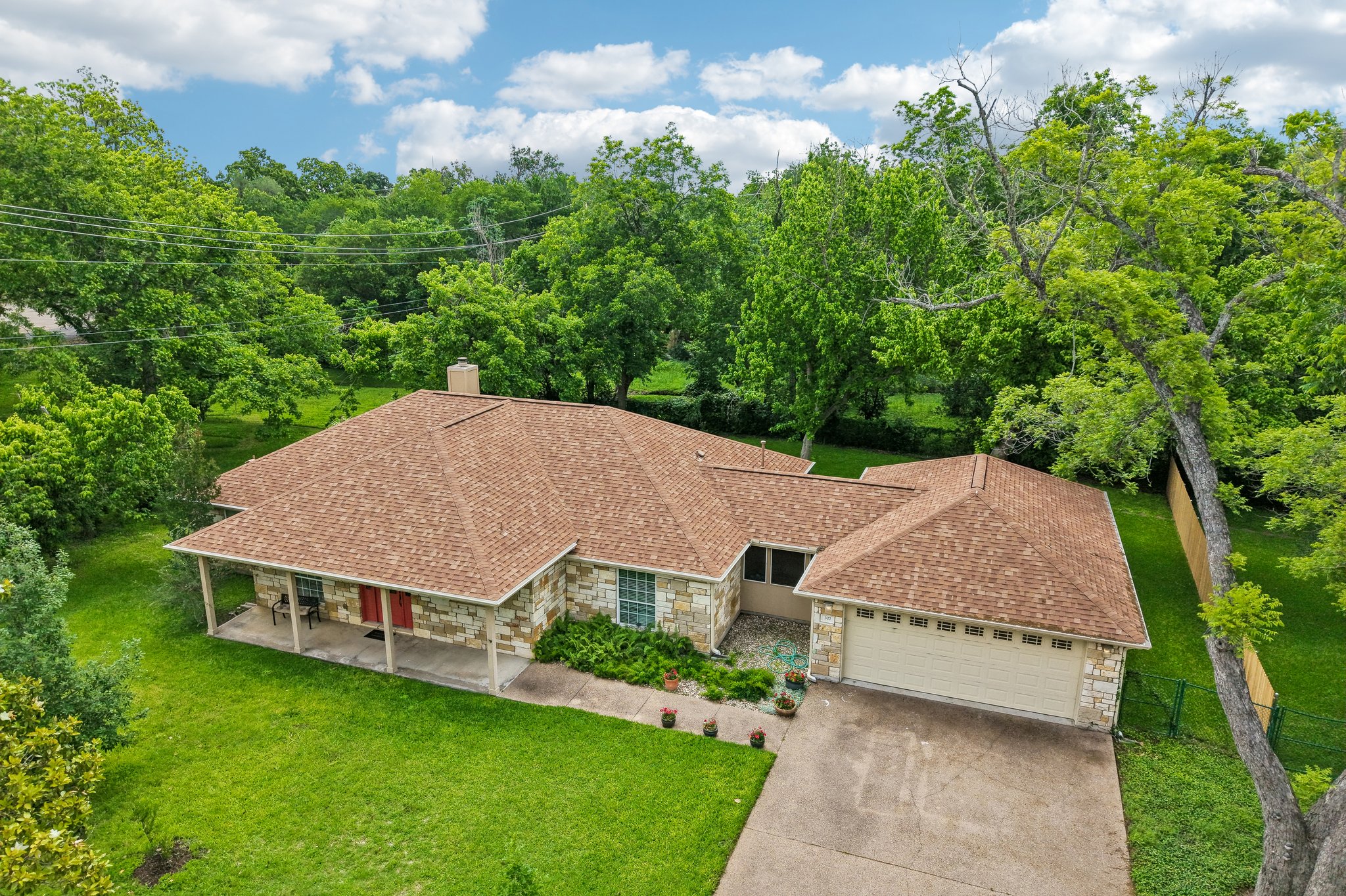 307 West 4th Street Elgin, TX 78621 - Photo 38 of 40 Ranch-style residence featuring a textured stone facade and a tan asphalt shingle roof