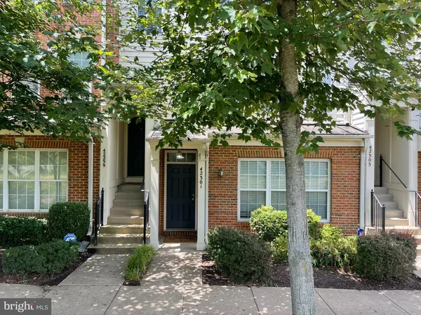 a front view of a house with a tree