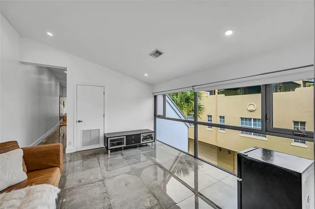 a large white room with a large window and a couch