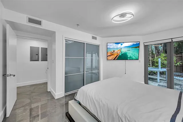 a bedroom with a bed and a large window