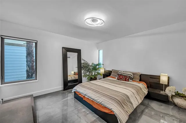 a bedroom with a bed and a lamp on dresser