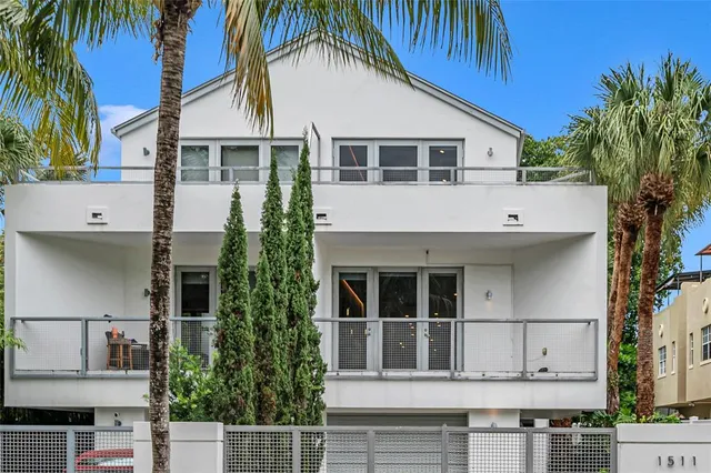 a view of white house with a yard and potted plants