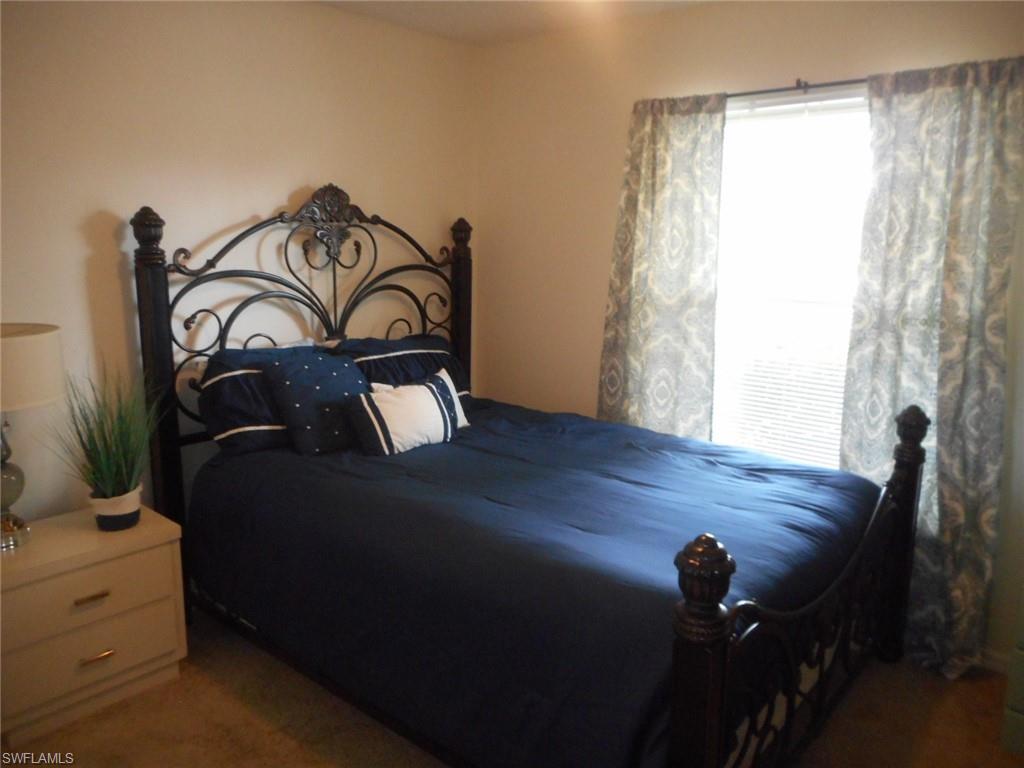 259 Quail Forest Boulevard, Unit 106 Naples, FL 34105 - Photo 12 of 23 a view of a bedroom with a bed
