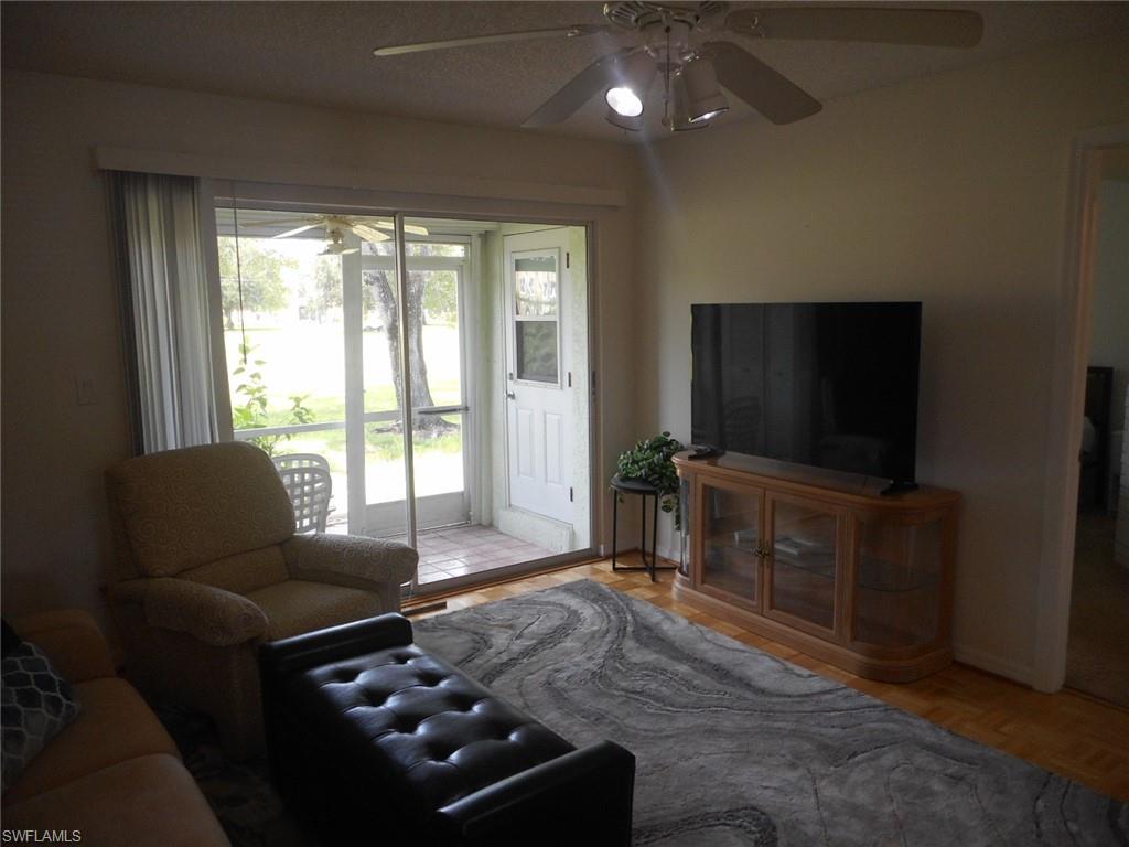 259 Quail Forest Boulevard, Unit 106 Naples, FL 34105 - Photo 7 of 23 a living room with furniture and a flat screen tv