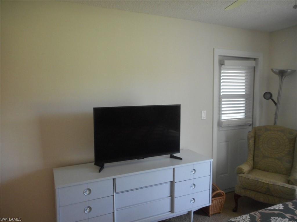 259 Quail Forest Boulevard, Unit 106 Naples, FL 34105 - Photo 9 of 23 a living room with furniture and flat screen tv