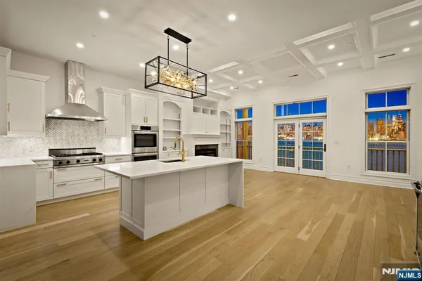 a large kitchen with stainless steel appliances granite countertop a stove and a sink