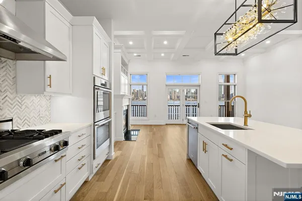 a kitchen with stainless steel appliances granite countertop a lot of counter space and wooden floors