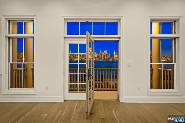 a view of a bedroom with wooden floor and windows