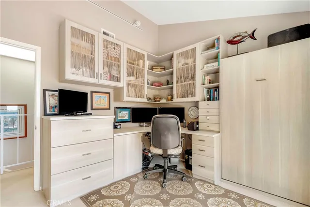 a view of a workspace with furniture and a window