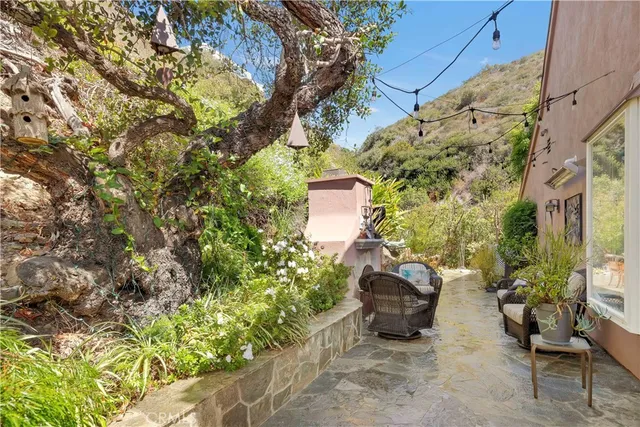 a backyard of a house with table and chairs and potted plants