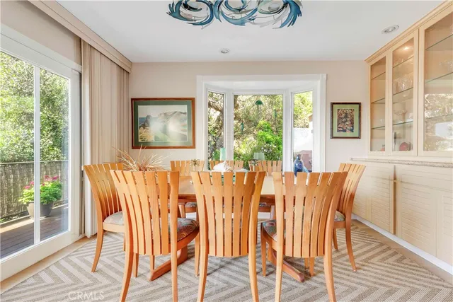 a view of a dining room with furniture large windows and wooden floor