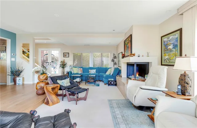 a living room with furniture a fireplace and a large mirror next to a window