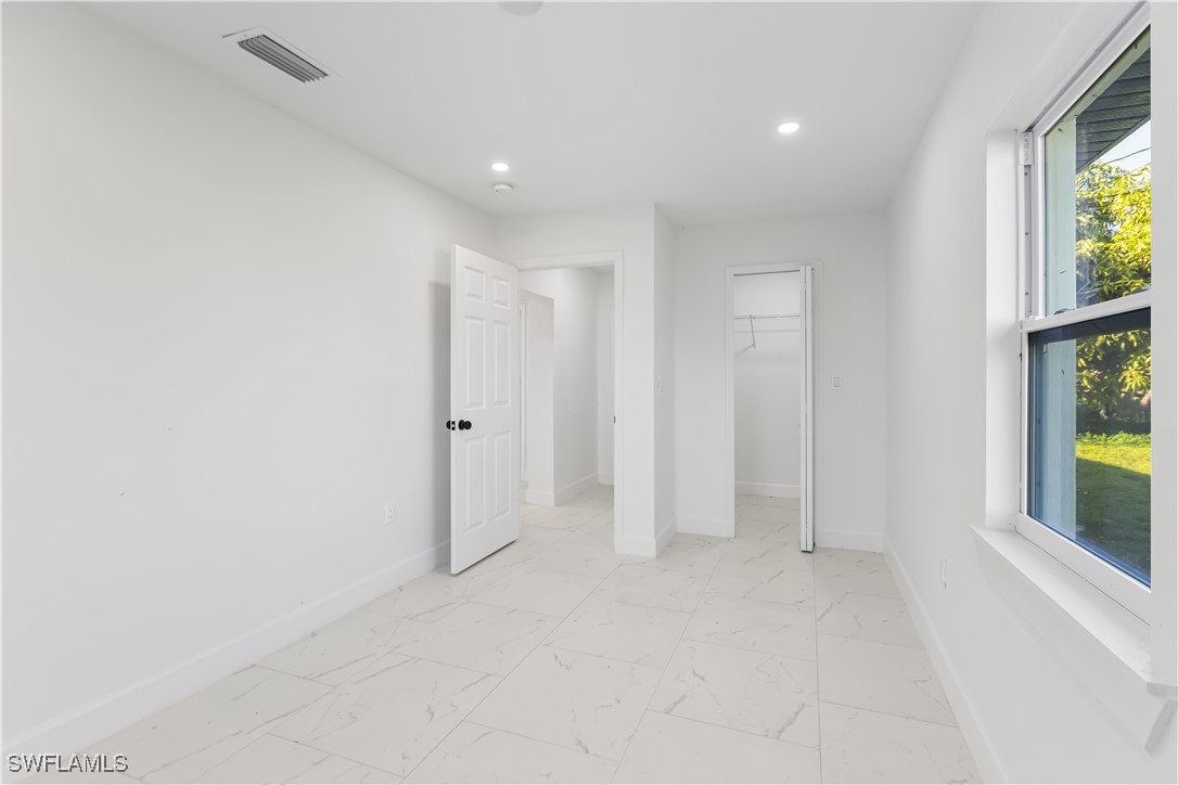 100 Wyoming Road Lehigh Acres, FL 33936 - Photo 14 of 38 an empty room with windows and garden view